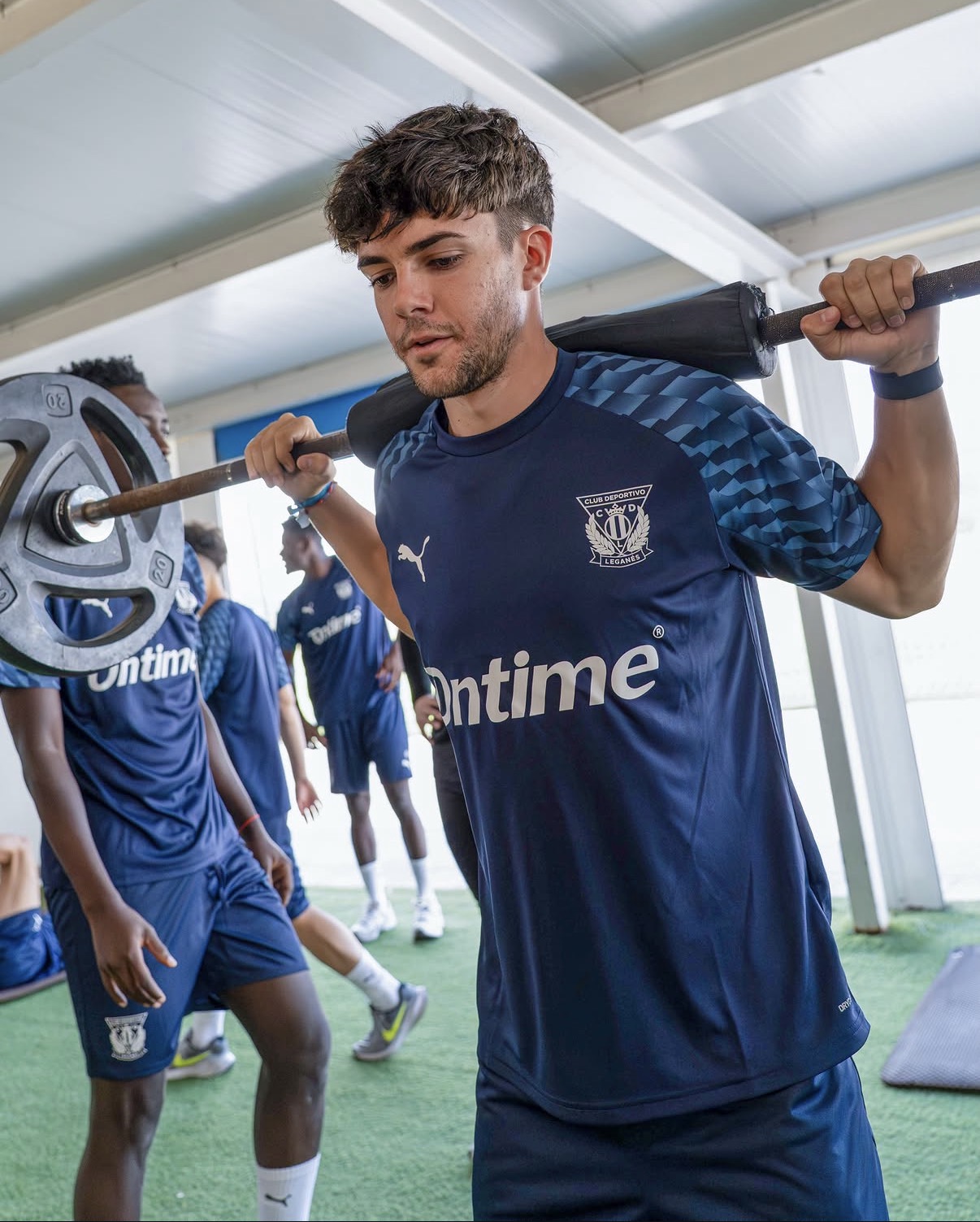 Jugador entrenando la fuerza mientras es observado en el entorno del C.D. Leganés